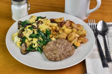 Sotelenmiş ıspanak ve soslu mantarlı omlet ve patates kızartması.