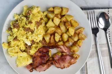 Sosisle karıştırılmış yumurta, domuz pastırması ve patates kızartması., 