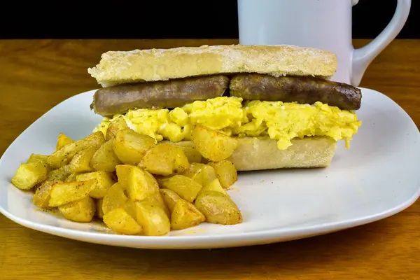 Ciabatta üzerine sosisli omlet ve patates kızartması.,