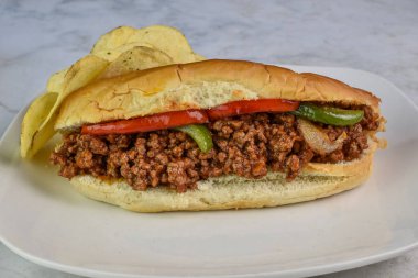 sloppy joe sub top with onions and peppers with a side of chips clipart
