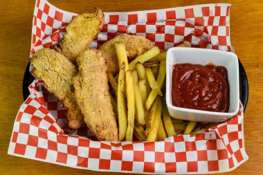 Kızarmış tavukla servis edilen parmak tavuk sepeti.