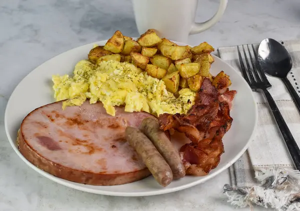 stock image scramble egg top with pepper and parsley served ham , bacon, sausage and home fries