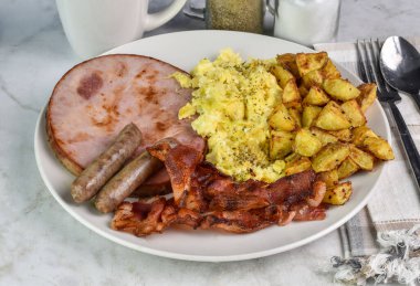 Biber ve maydanozlu omlet jambon, domuz pastırması, sosis ve patates kızartması.