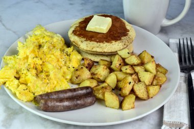 Biberli omlet ve krep, sosis ve patates kızartması ile servis edilen otlar.