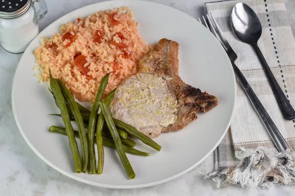 stock image pork chop top with onion and garlic salt  served with rice  and tomatoes,