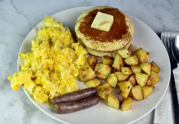 stock image scramble eggs top with pepper and herbs served with pancakes, sausage and home fries