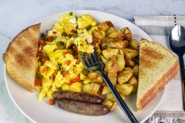 Biberli omlet, yanında patates kızartması ve sosis.