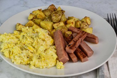 Çırpılmış yumurta, kızarmış konserve jambon ve patates kızartması..