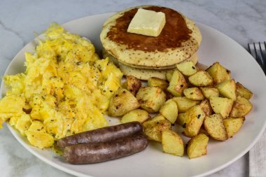 Biberli omlet ve krep, sosis ve patates kızartması ile servis edilen otlar.