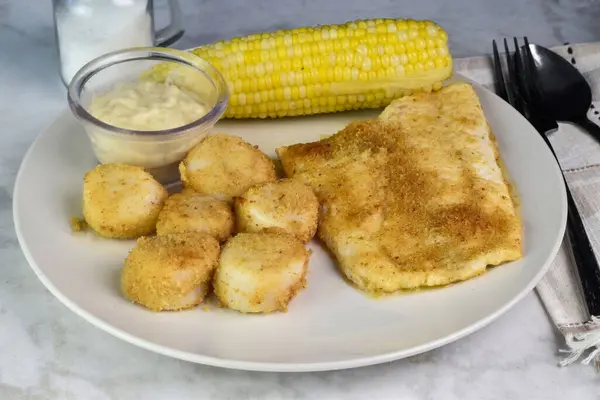 stock image baked haddock  served with  baked scallops and  corn