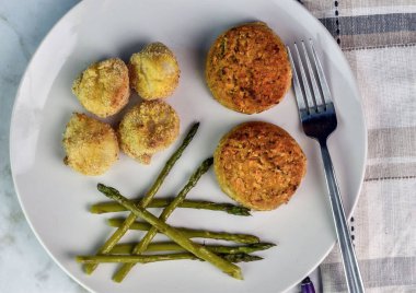  baked scollops served with crab cakes and asparagus clipart