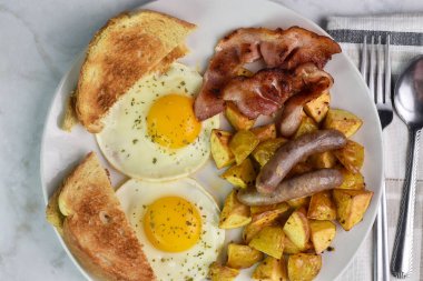 Domuz pastırması ve sosis ile servis edilen maydanozlu yumurta..