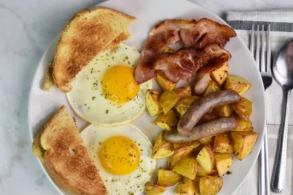 Domuz pastırması ve sosis ile servis edilen maydanozlu yumurta..