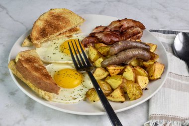 Domuz pastırması ve sosis ile servis edilen maydanozlu yumurta..