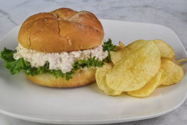 Tavuk salatalı sandviç yanında patates kızartması.