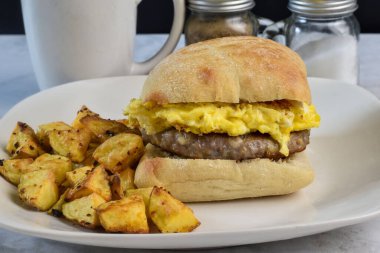 Patates kızartmasıyla servis edilen çöreğin arasında sosisli böreğin üstünde çırpılmış yumurta.