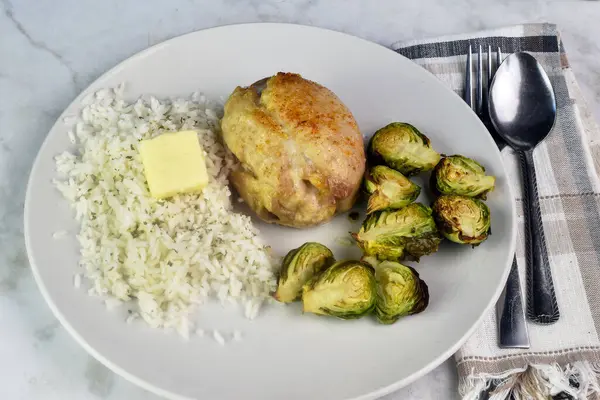 Pirinçli tavuk budu tereyağlı ve maydanozlu brussel lahanalı.