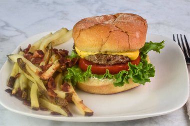 cheese burger  with lettuce and tomato  on a bulkie roll served with  home made fries top with bacon clipart