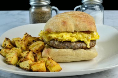 Patates kızartmasıyla servis edilen çöreğin arasında sosisli böreğin üstünde çırpılmış yumurta.