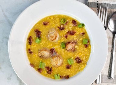 Kremalı mısır, domuz pastırması ve soğanla servis edilen kurutulmuş deniz tarakları.