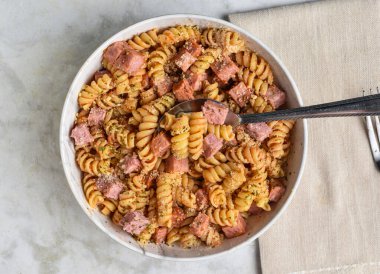 Maydanoz, biber ve doğranmış jambonlu parmesan peynirli fusilli makarna.