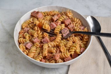 Maydanoz, biber ve doğranmış jambonlu parmesan peynirli fusilli makarna.
