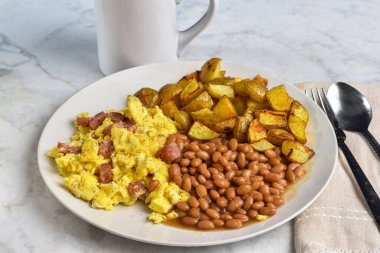 Konserve jambonlu omlet ve fırında fasulye ve patates kızartmasıyla servis edilen biber..