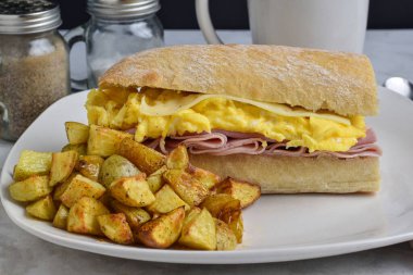 jambon, çırpılmış yumurta ve ciabatta sandviç ekmeğinde servis edilen İsviçre peyniri.,