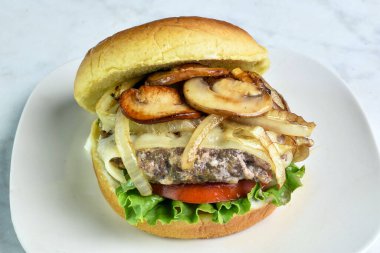 Hamburger, marul, soğan ve mantarlı çörek.