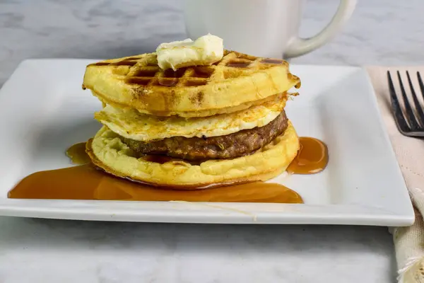Sosisli börek ve kızarmış yumurta krep üstü ve şurup arasında servis ediliyor.