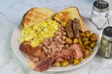 Çırpılmış yumurta, maydanozlu domuz pastırması, sosis ve patates kızartması.