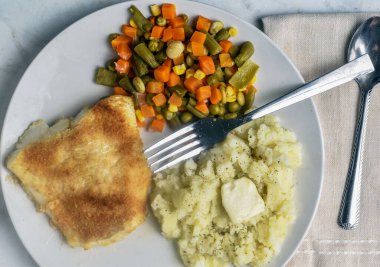 fırında morina ve patates püresi, maydanozlu ve migren sebzeli.