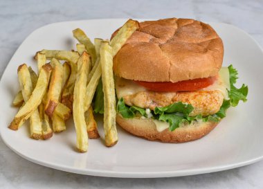 chicken  fillet  with  lettuce, tomato and cheese on a  bulkie roll served with fries clipart