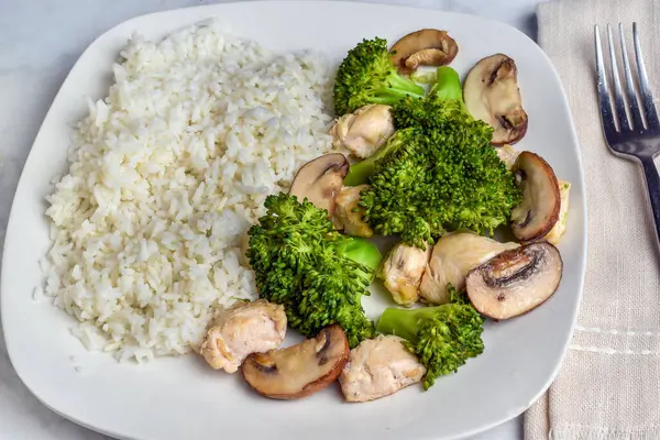 stock image  white rice  served with  steamed broccoliu and sauteed mushrooms