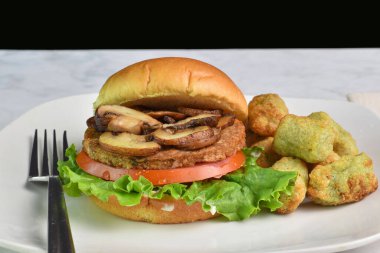 Domatesli sebze mantarlı burger ve brokoli kızartmasıyla servis edilen marul.