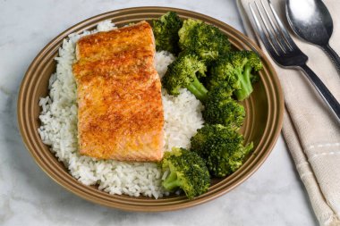 ızgara somon pilav ve buğulanmış brokoli servis edilir..