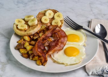 Patates kızartmalı sahanda yumurta ve domuz pastırması yanında da fıstık ezmeli ve muzlu kek.