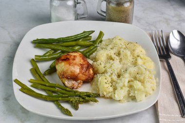 Barbekü tavuk budu kuşkonmaz ve patates püresi ile servis edilen fasulye maydanoz ve biber.,