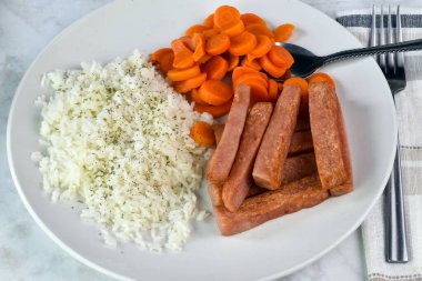 Maydanozlu beyaz pirinç üstü ve patates kızartması ve havuçla servis ediliyor..