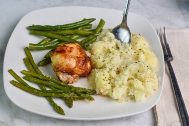 Barbekü tavuk budu kuşkonmaz ve patates püresi ile servis edilen fasulye maydanoz ve biber.,