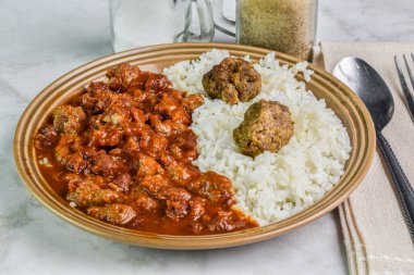 Kırmızı biberle servis edilen köfteli pilav.