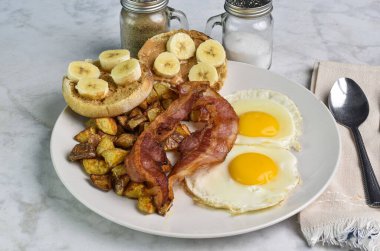 Patates kızartması ve domuz pastırmalı patates kızartması. Yanında da İngiliz keki, fıstık ezmesi ve muz.