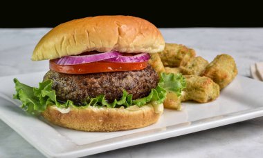 Domatesli portobello burger üstü ve brokoli soslu dilimlenmiş soğan.,