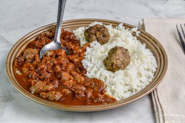 Kırmızı biberle servis edilen köfteli pilav.