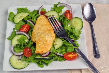 Bahçe salatasıyla servis edilen tavuk göğsü.