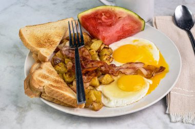 Jambonlu sahanda yumurta, patates kızartması ve bir dilim karpuz..