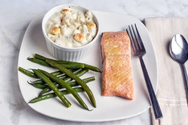 Fırında somon, deniz tarağı çorbası ve yeşil fasulye ile servis edilir.