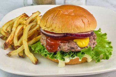 Ketçaplı, hardallı ve soğanlı hamburgerli çörek.