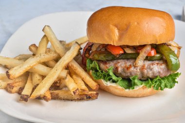 Sotelenmiş soğan ve biberli İtalyan sosisi Brioche ekmeğine servis edilir.