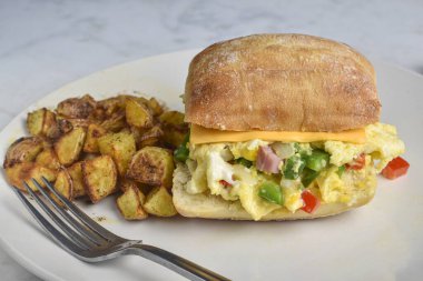 Biber dilimlenmiş yumurta, soğan ve ciabatta ekmeğinde servis edilen peynirli jambon.